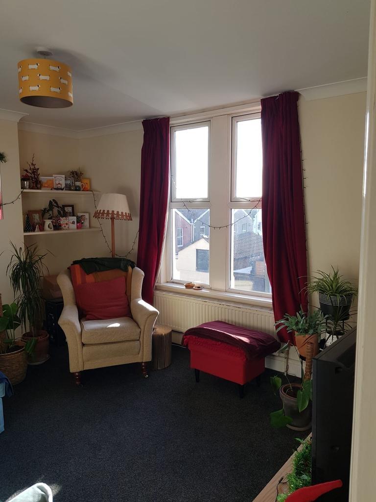 Bright, cosy living room with a large window fr...