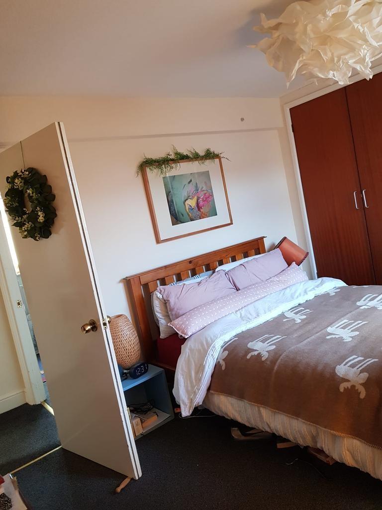 Bright, cosy bedroom with a wooden headboard, d...