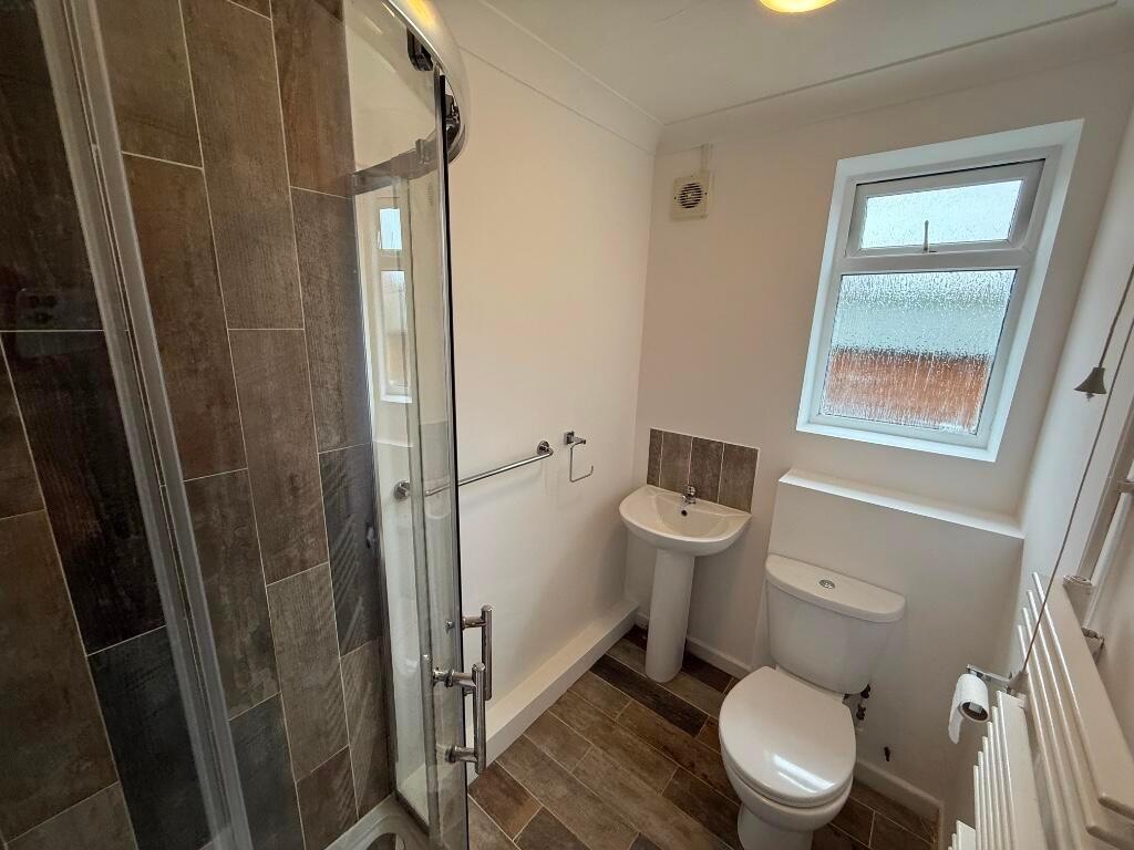 Bright, modern bathroom with a corner shower cu...