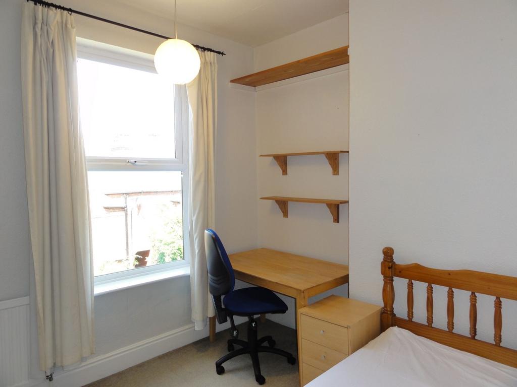 Bright, well-kept bedroom with a large window, ...