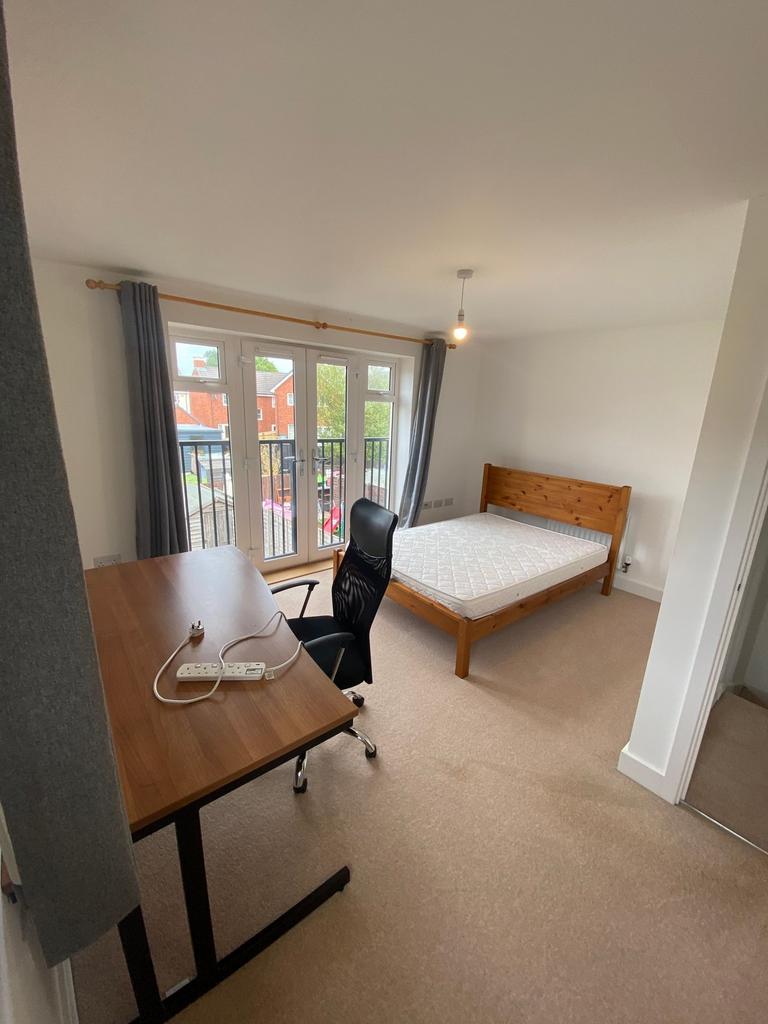Bright double bedroom with a wooden bed frame, ...