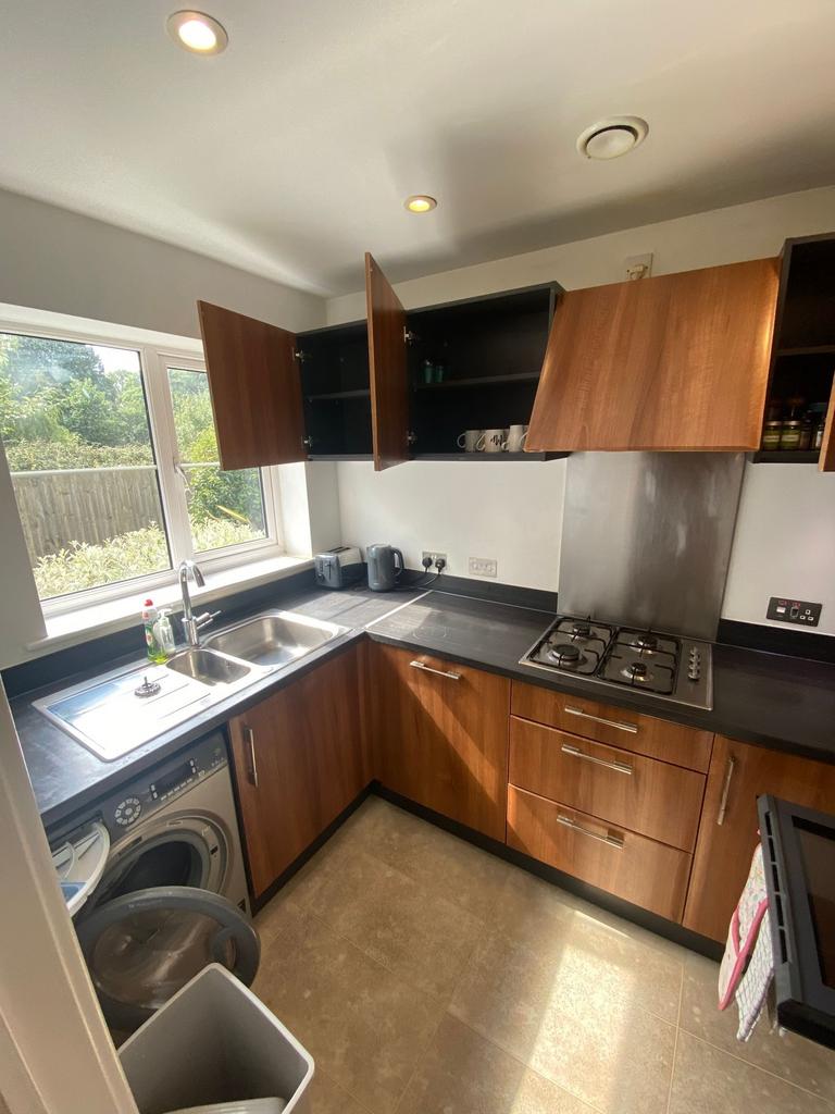 Bright modern galley kitchen with wood-effect c...