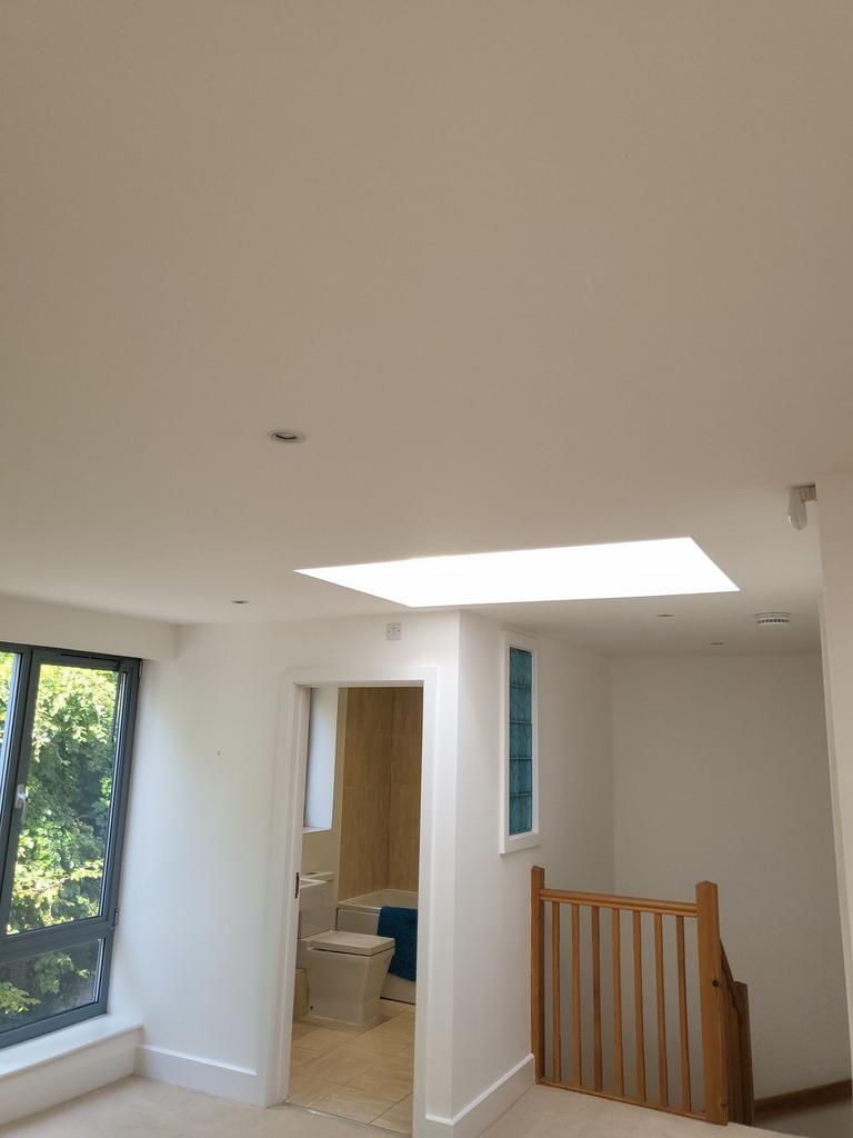 Bright landing area with a large skylight, wind...