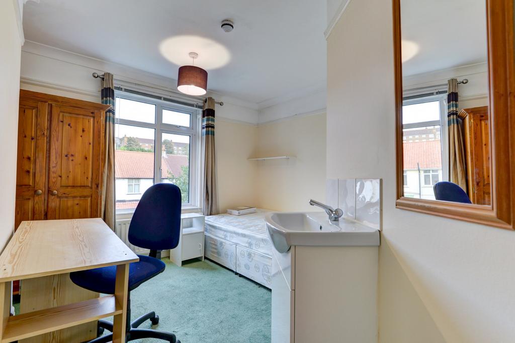 A bright and tidy student bedroom featuring a s...