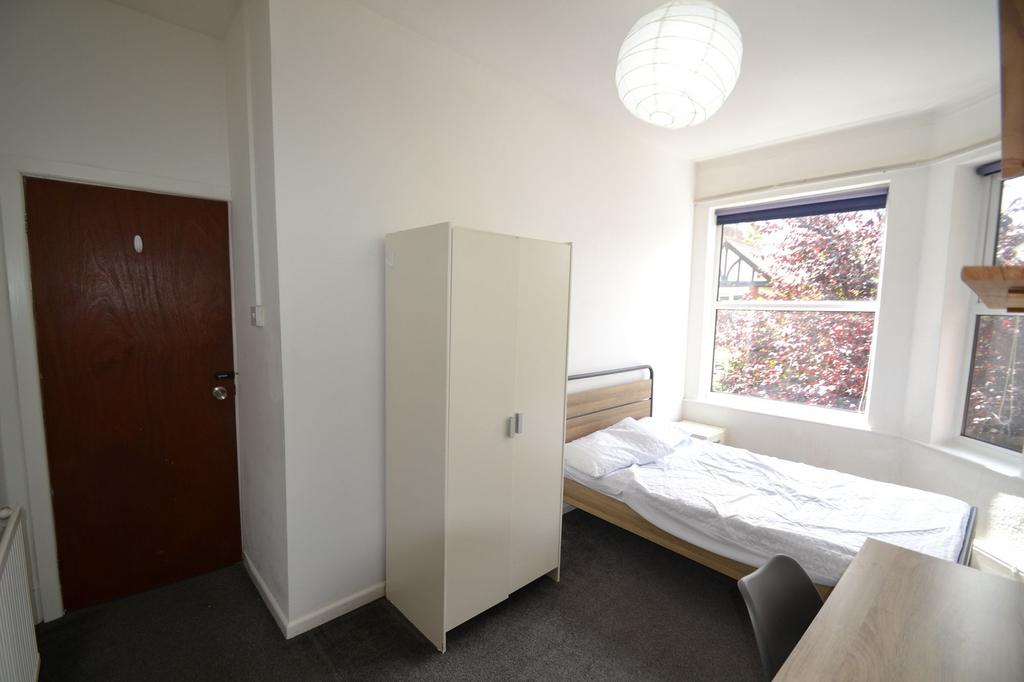 Bright and cozy bedroom featuring a single bed,...