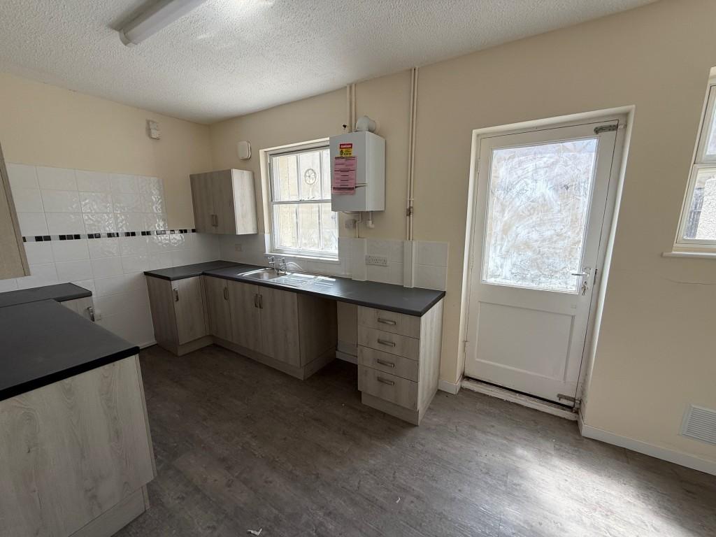 Kitchen with gas boiler, back door and two windows