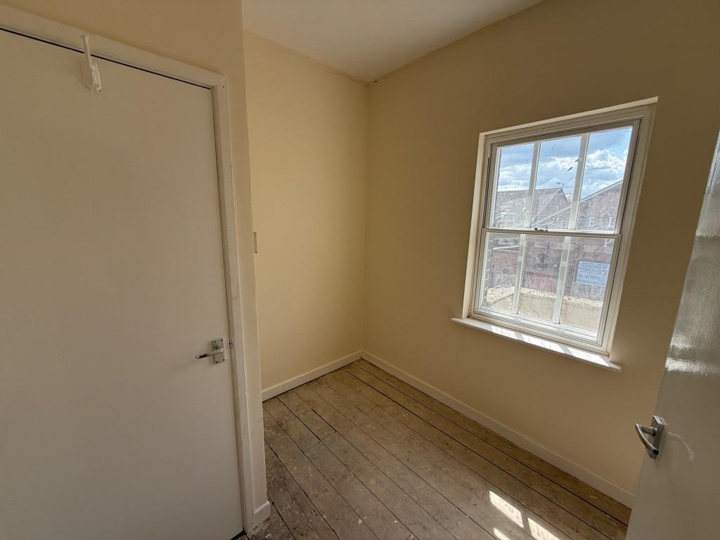 Bedroom three with cupboard and window to rear
