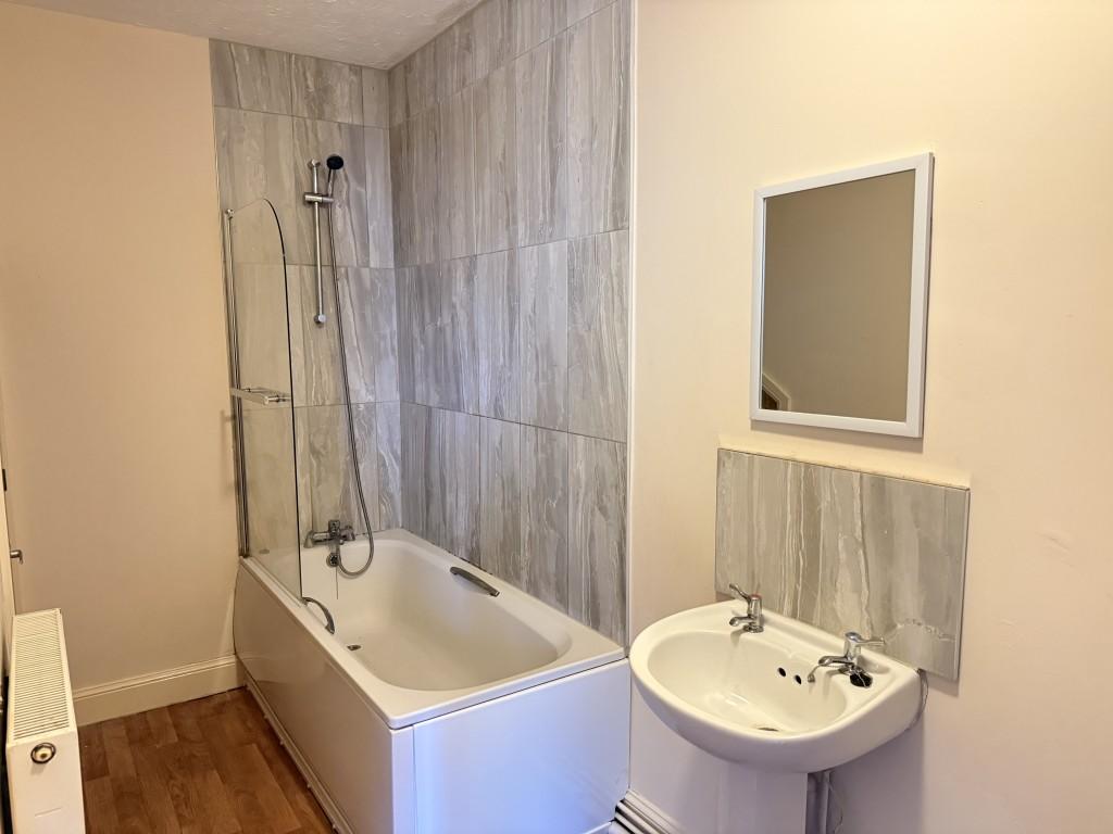Bathroom with white suite and tiles around bath