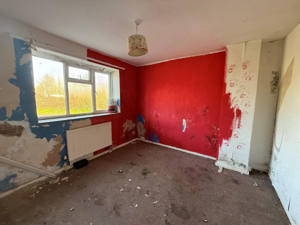 Carpeted 2nd bedroom with window and radiator