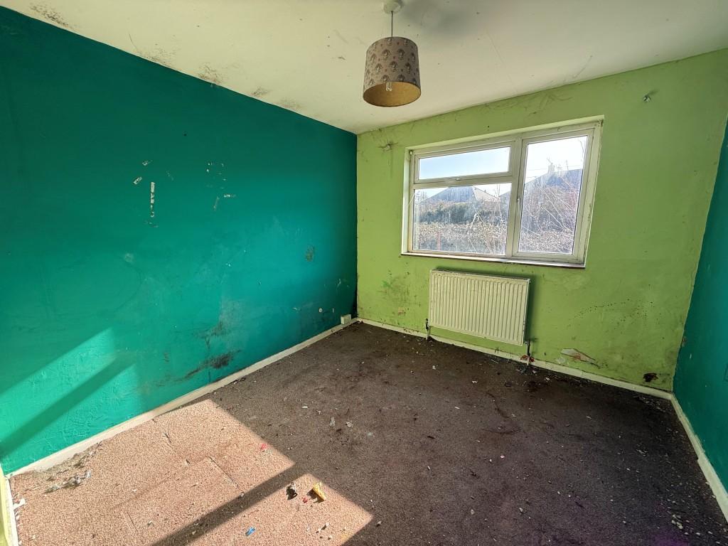 Carpeted 3rd bedroom with window and radiator