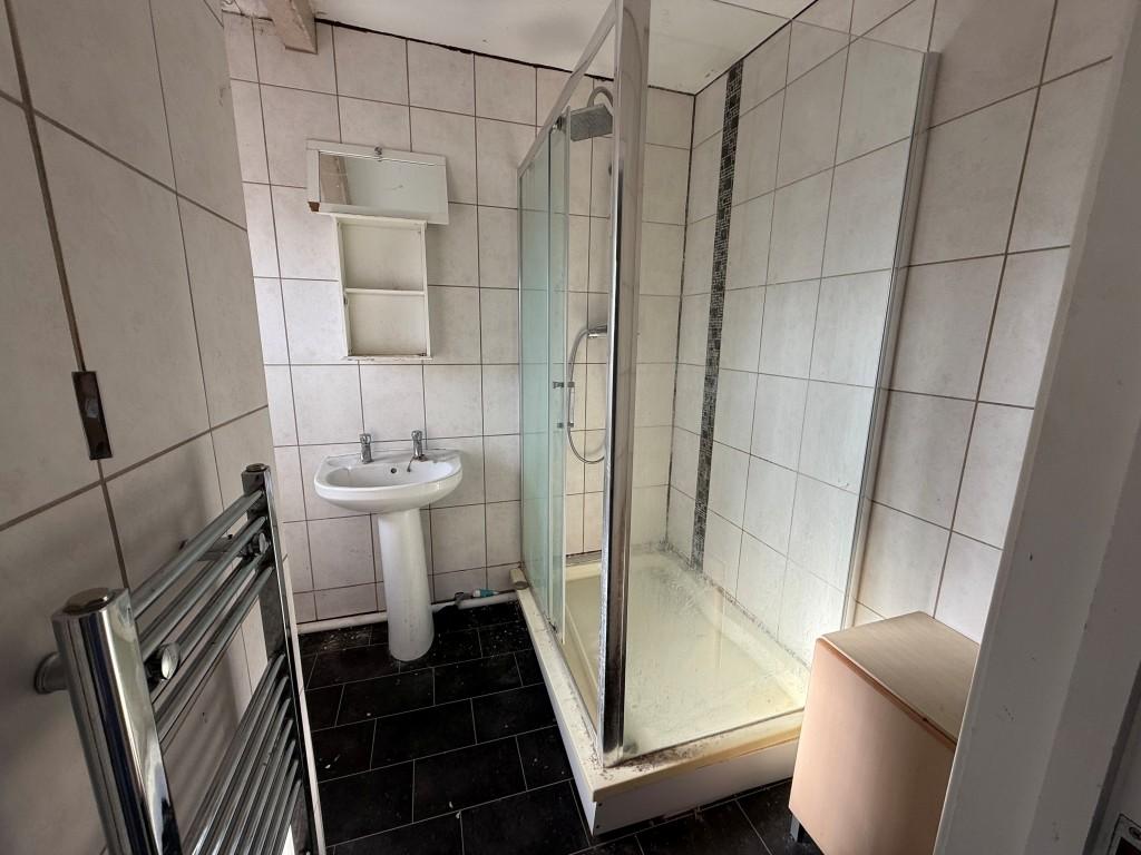 Tiled ensuite with shower, radiator and sink