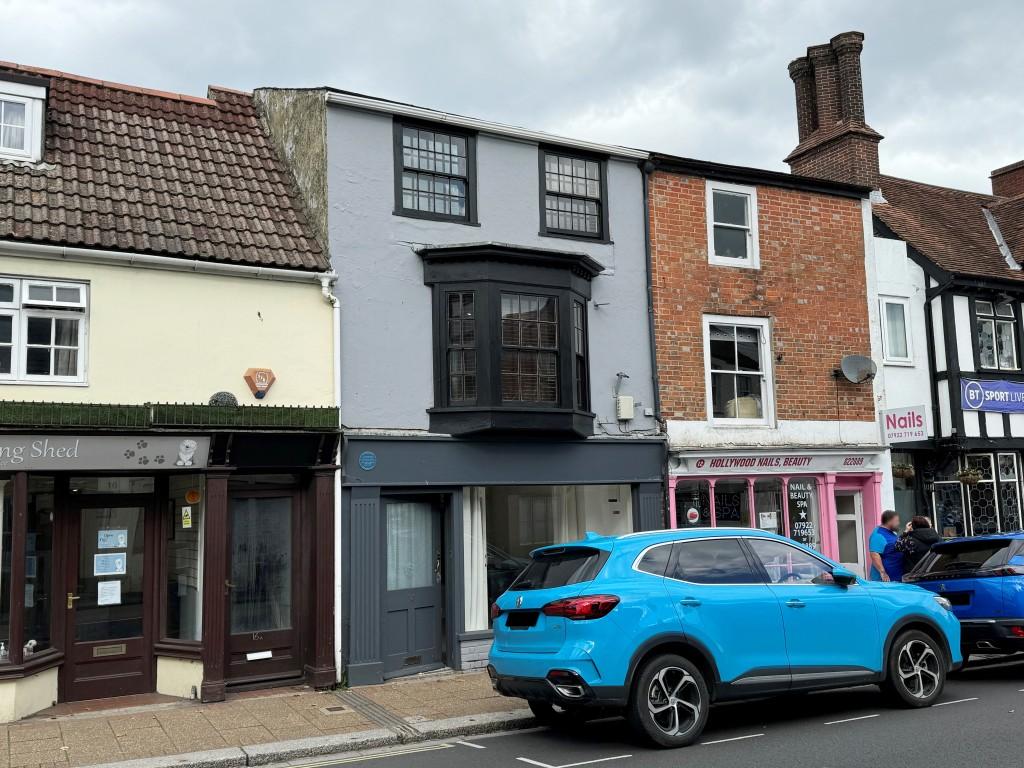 Terraced building painted grey with commercial uni