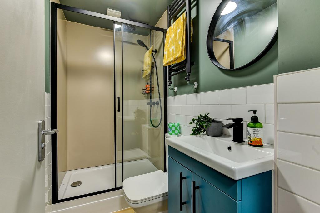 Modern, well‑kept bathroom with a glass shower ...