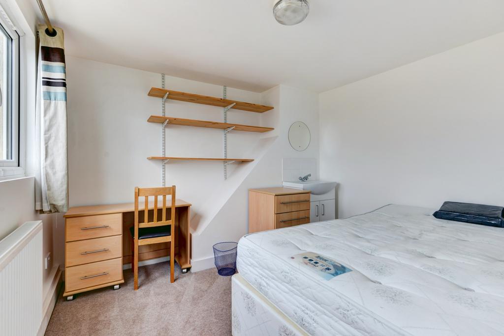 A bright and tidy bedroom featuring a comfortab...