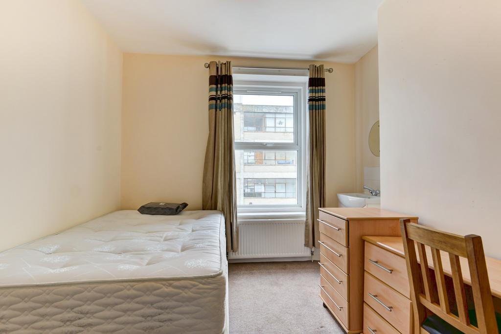 Bright, simply furnished bedroom with a large w...