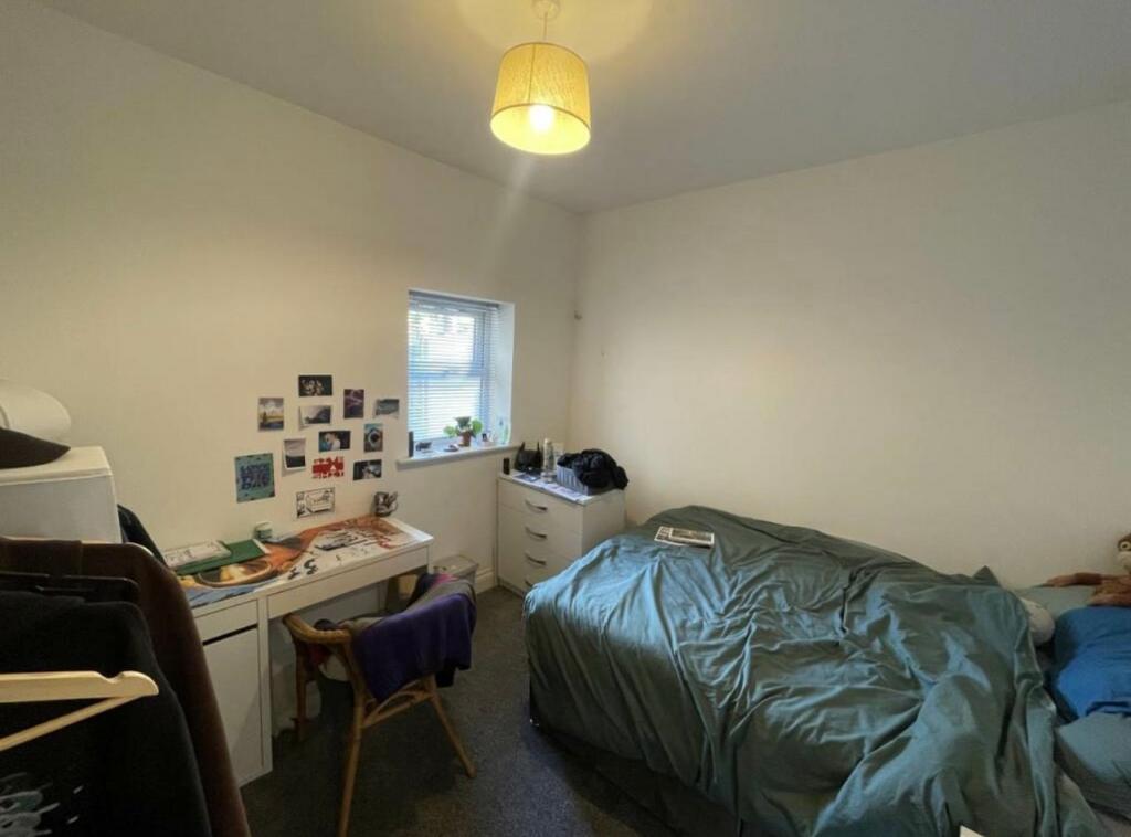 Bright, simply furnished bedroom with a double ...