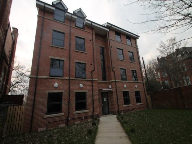 Well-kept brick building with lawned entrance...