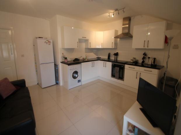 Modern open-plan kitchen with integrated white ...