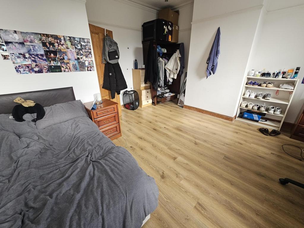 Bright furnished bedroom with wood flooring...