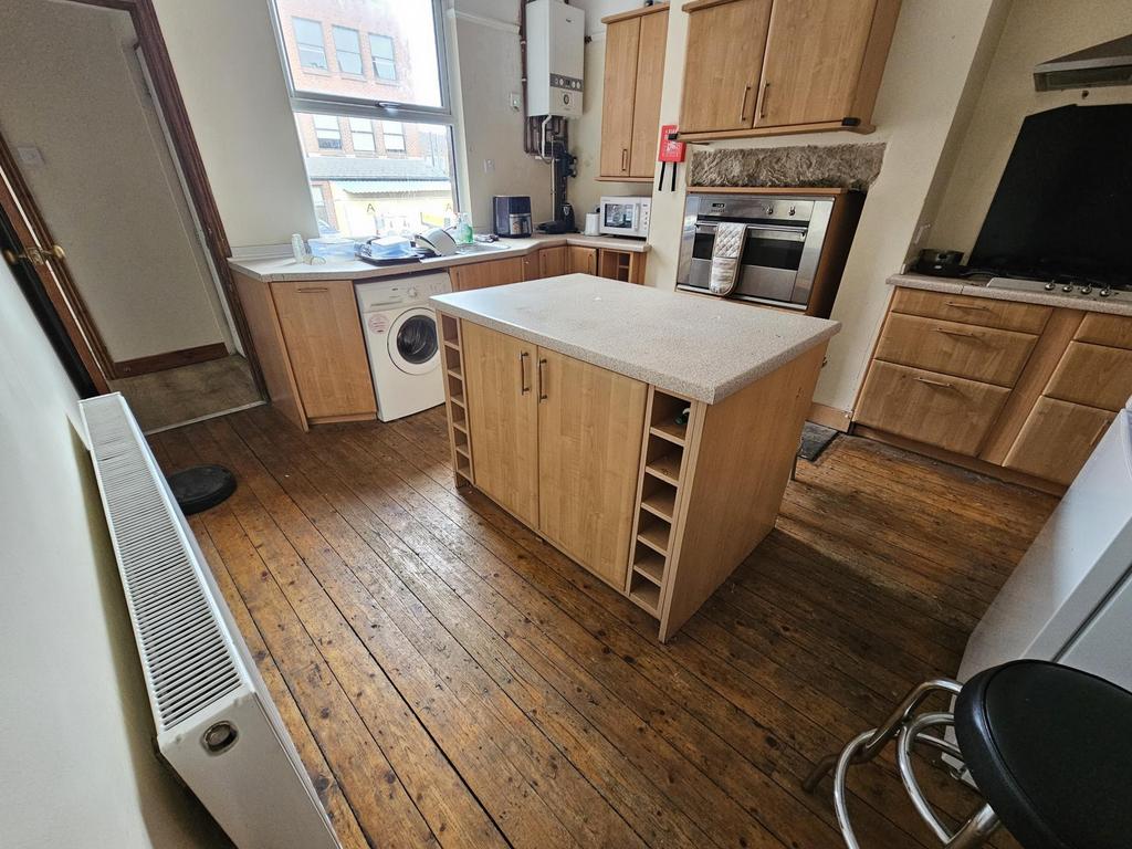 Bright kitchen with central island and woodenfl...