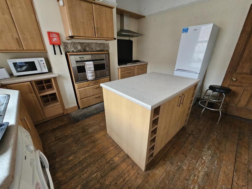 Bright fitted kitchen with central island and w...