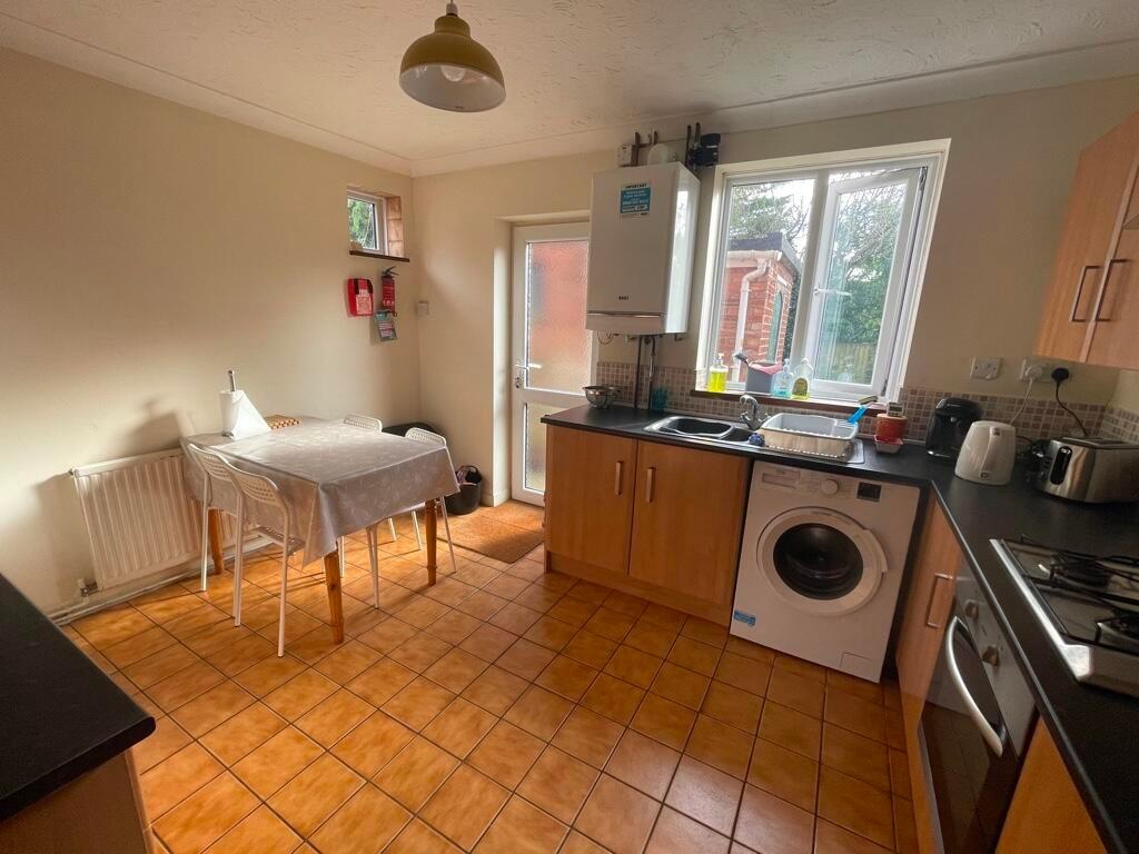Bright fitted kitchen with natural light from a...
