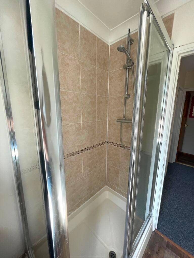 Compact tiled shower cubicle with glass folding...