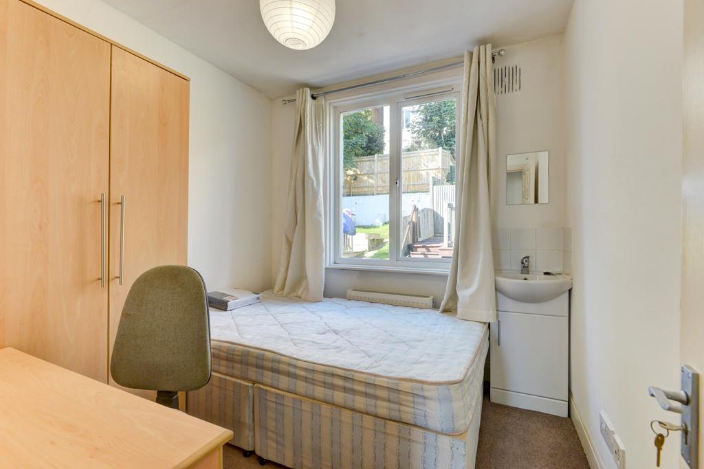 A well-lit bedroom featuring a comfortable sing...
