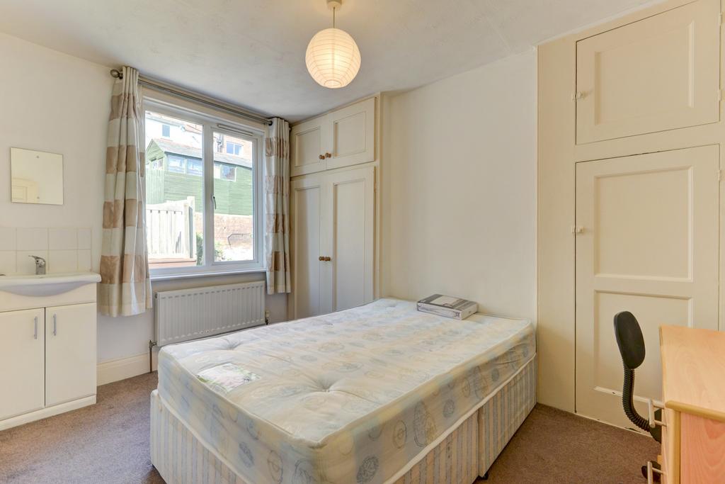 A cozy single bedroom with a comfortable bed, a...