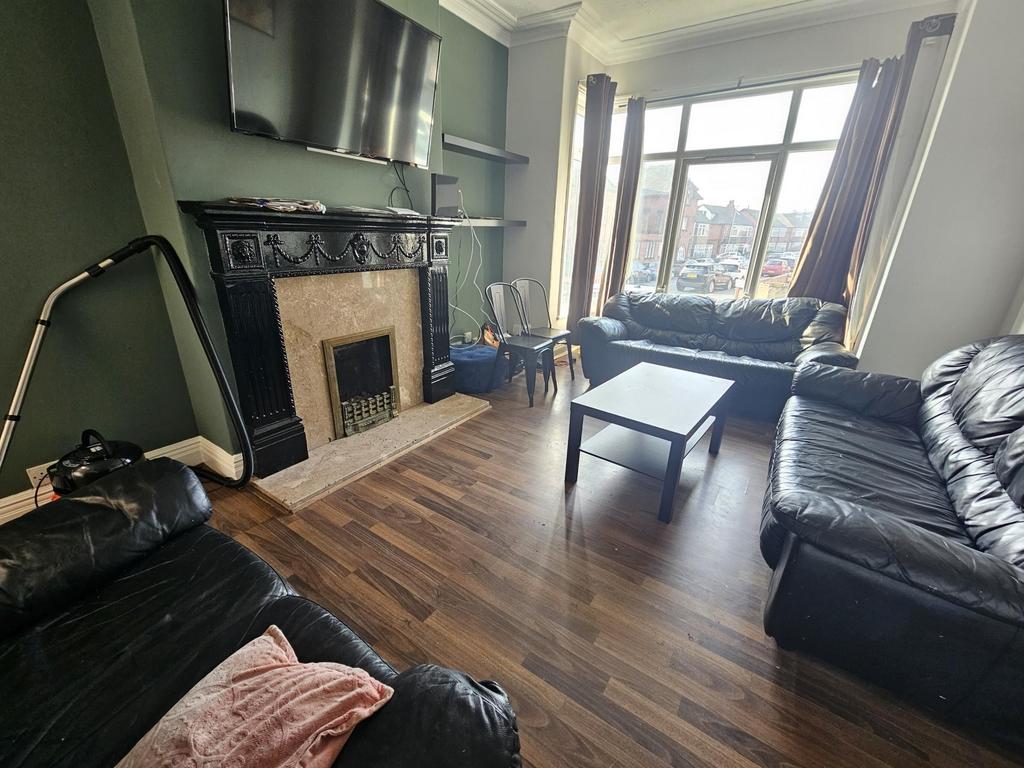 Bright living room with bay window and fireplac...