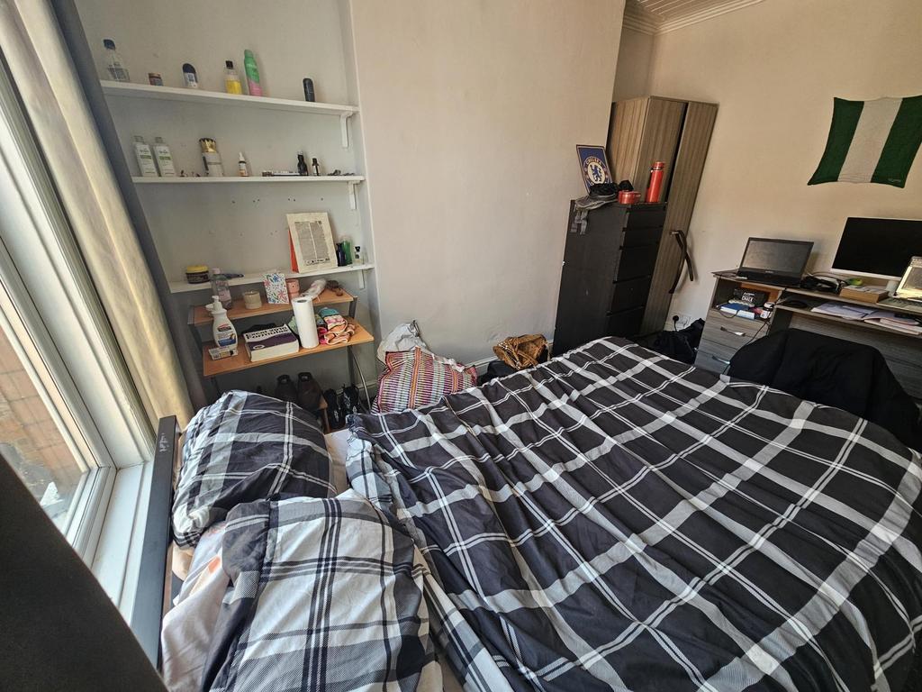 Cozy bedroom with large window and storage shel...