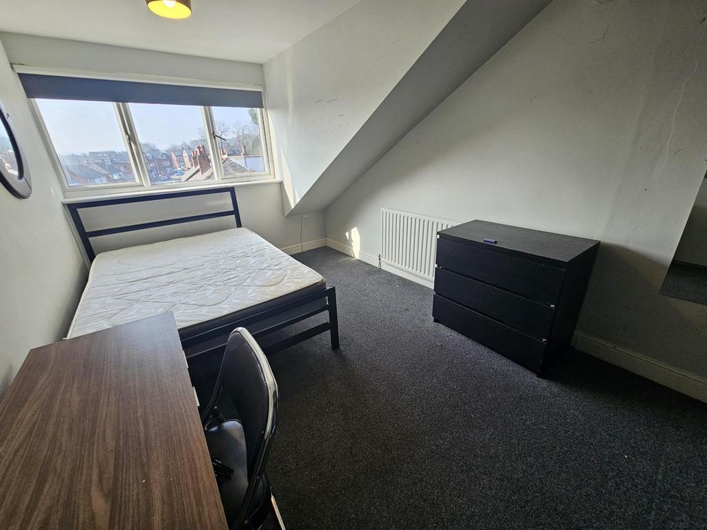Bright furnished bedroom with desk and storage...