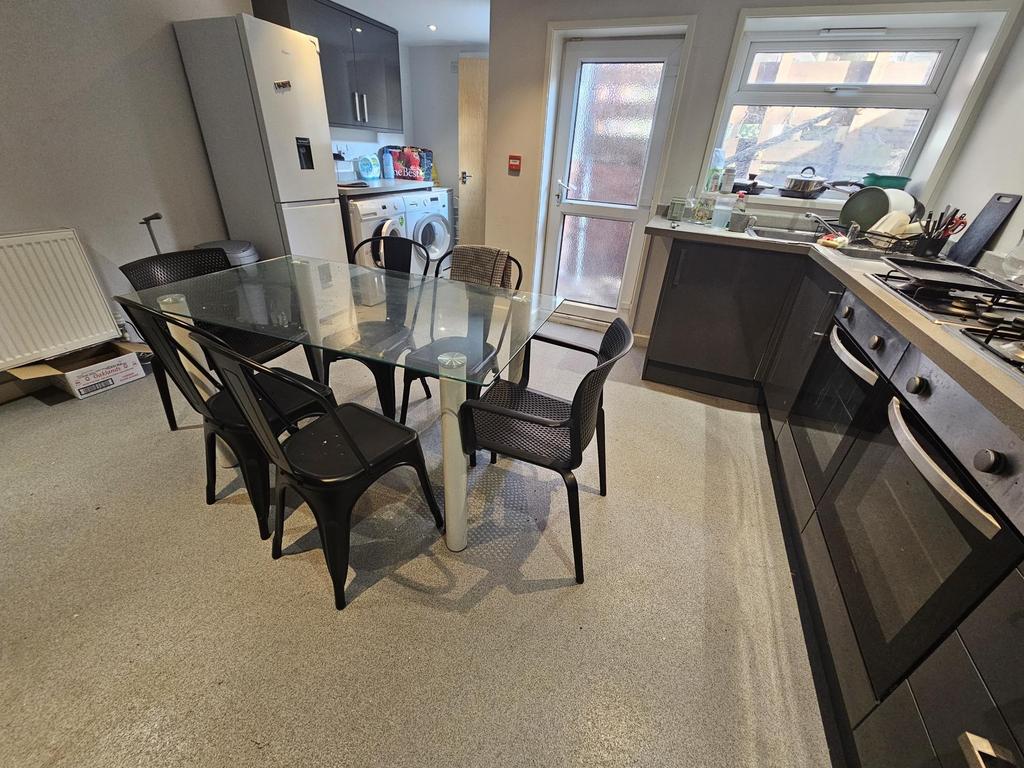 Modern kitchen with dining table and bright win...