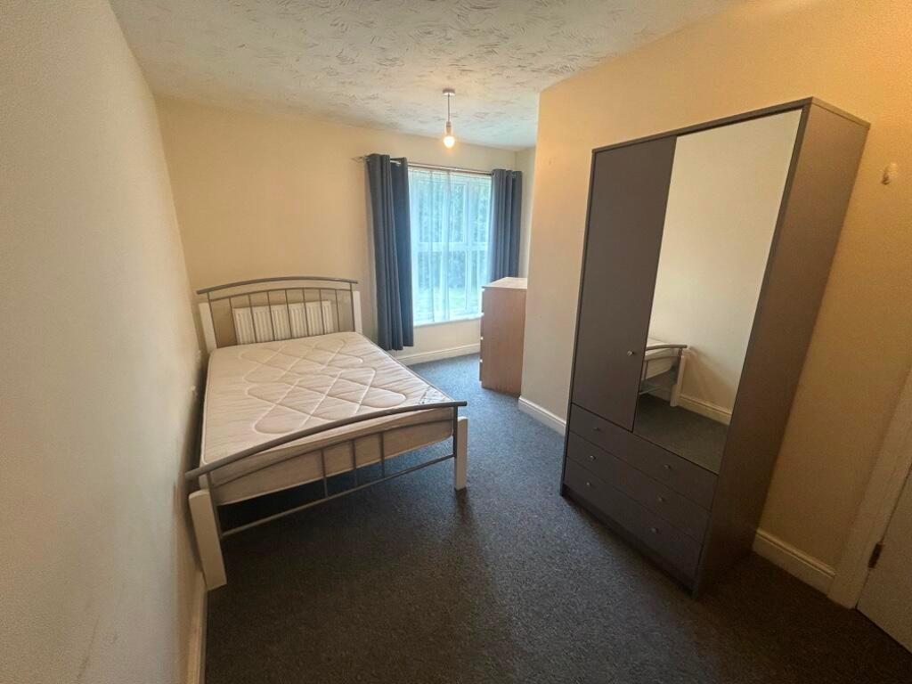 Bright, simply furnished bedroom with a double ...