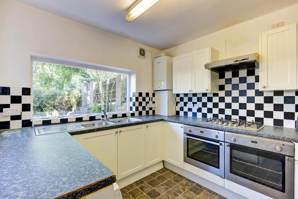A clean and well-lit kitchen featuring white ca...
