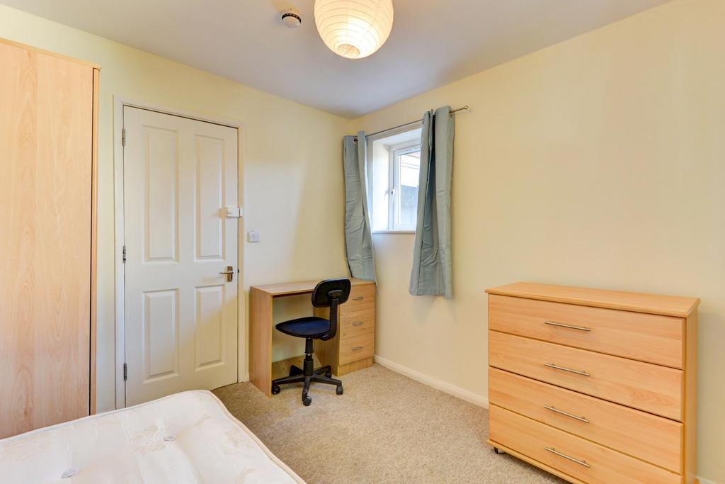 Bright, simply furnished bedroom with a comfort...