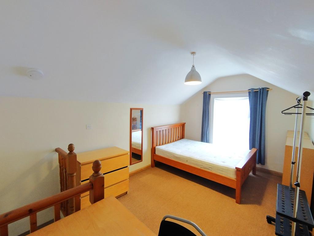 Bright, neatly presented bedroom with a wooden ...
