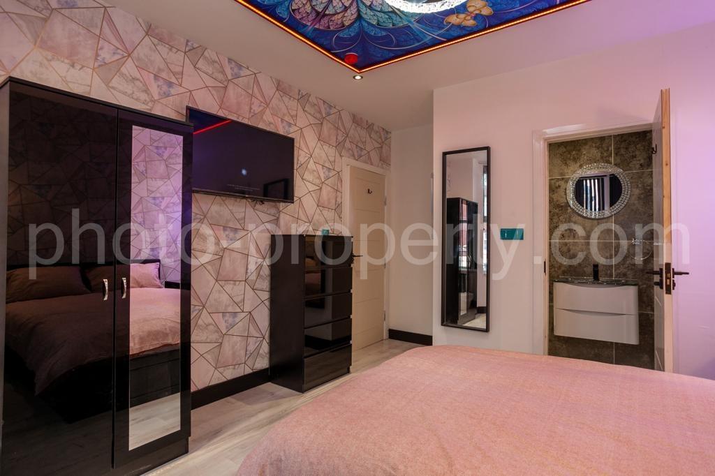 Stylish double bedroom with patterned feature w...