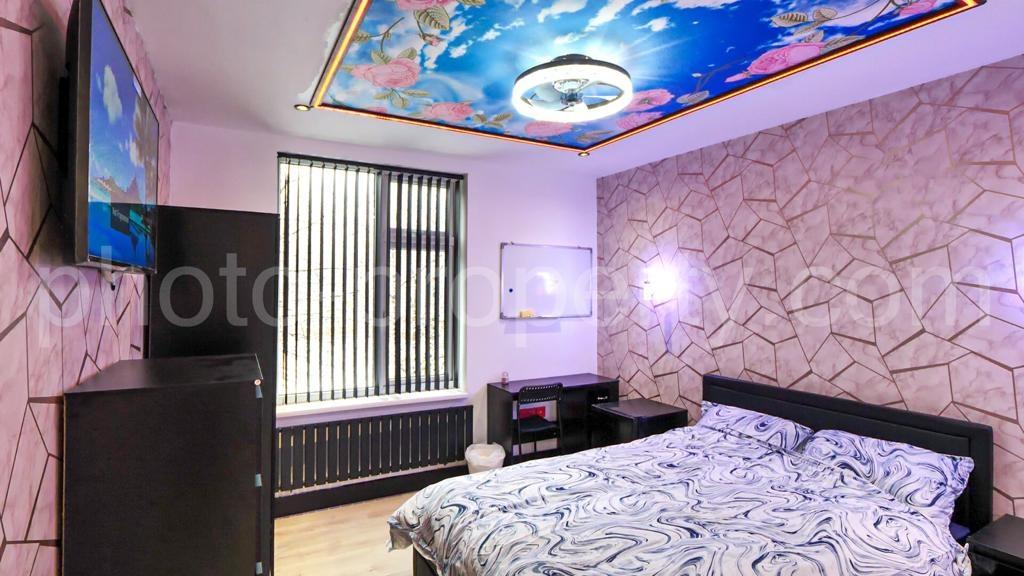 Stylish double bedroom with patterned accent wa...
