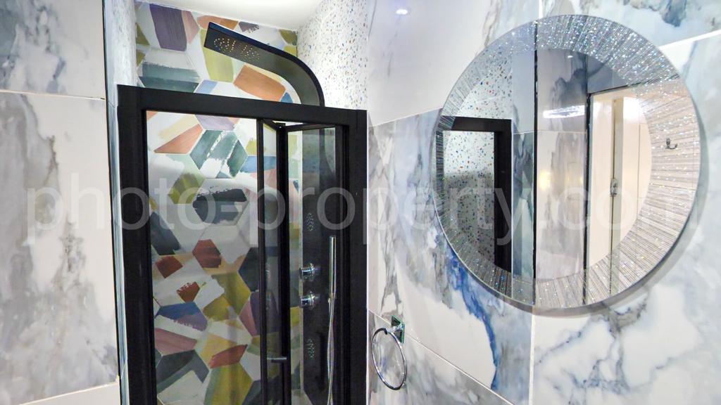 Modern bathroom with a framed glass shower encl...