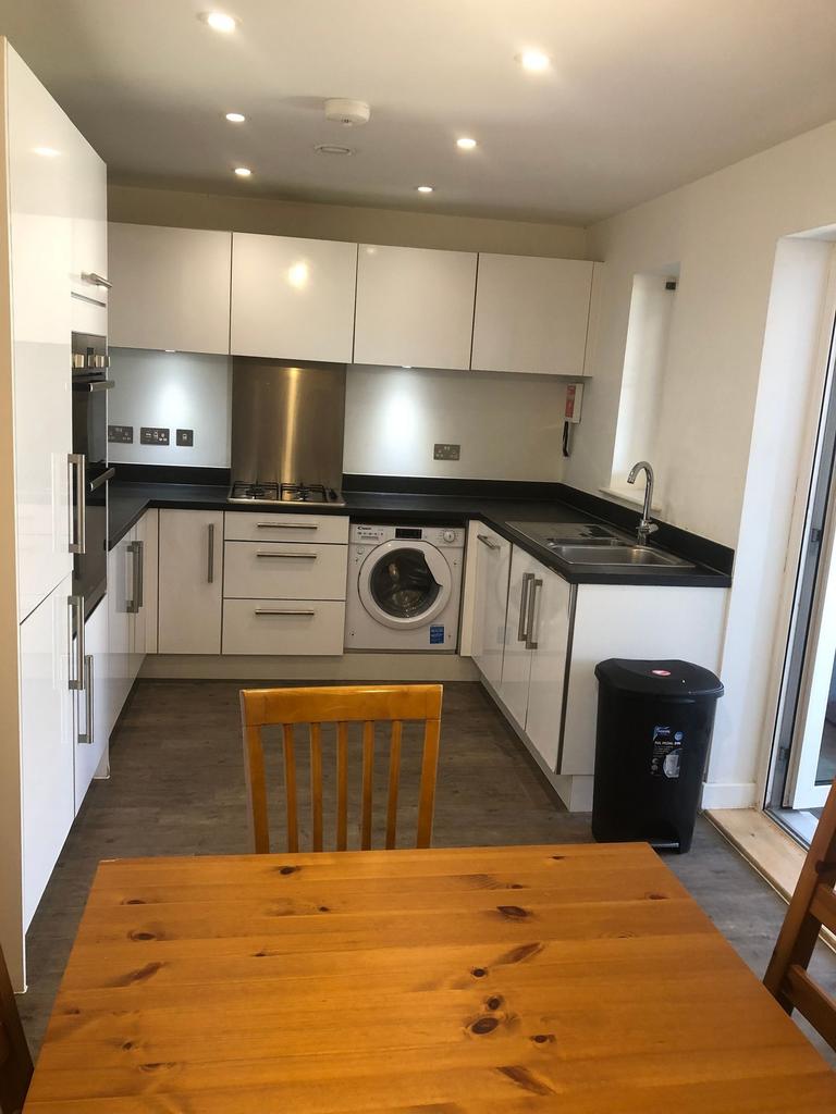 Bright modern kitchen with white high-gloss cab...