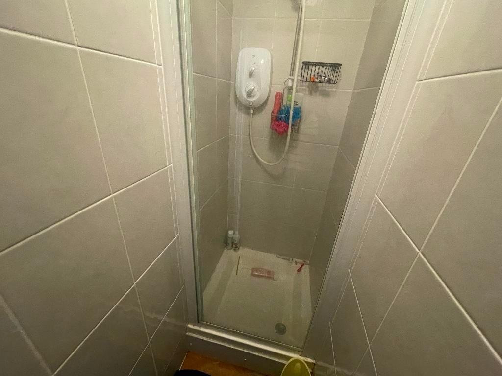 Compact tiled shower cubicle with an electric s...