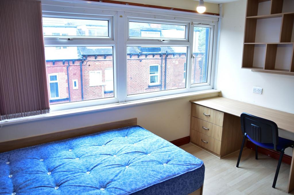Bright and tidy bedroom featuring a large windo...