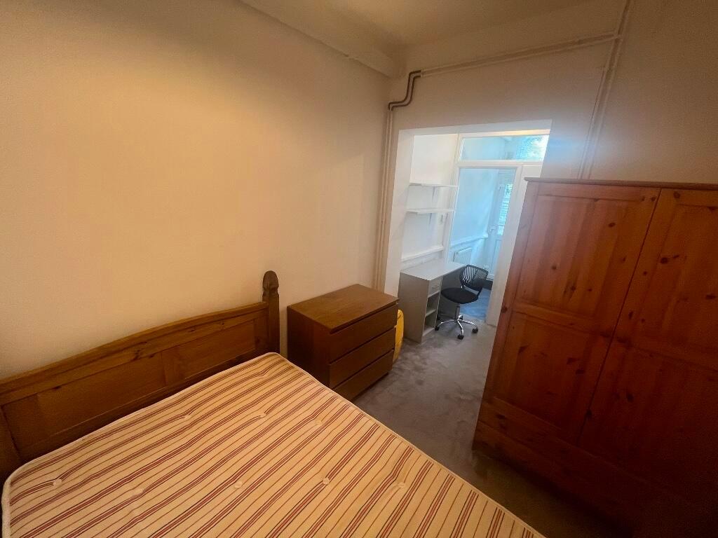 Cosy bedroom with wooden bed frame and matching...