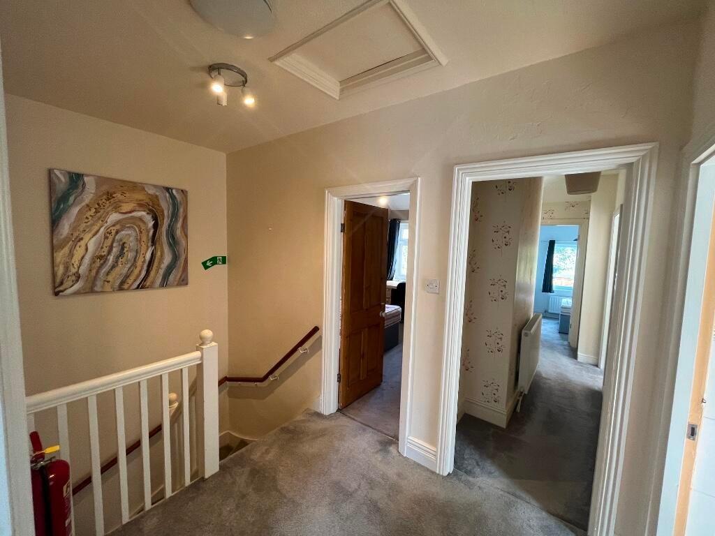 Bright carpeted landing with neutral walls, dec...