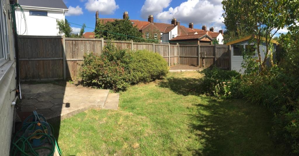 Sunny, enclosed rear garden with a lawn, mature...