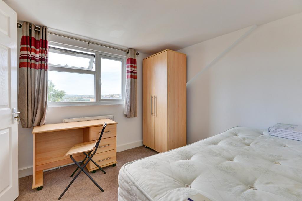 Bright, simply furnished bedroom with a large w...