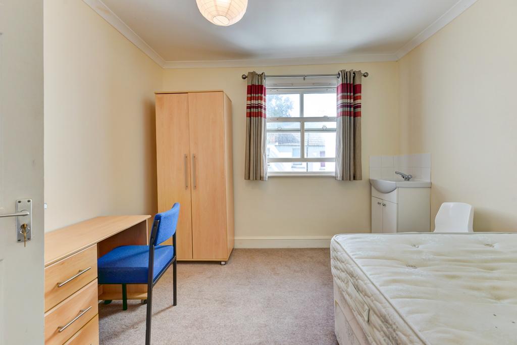 Bright, simply furnished bedroom with a double-...