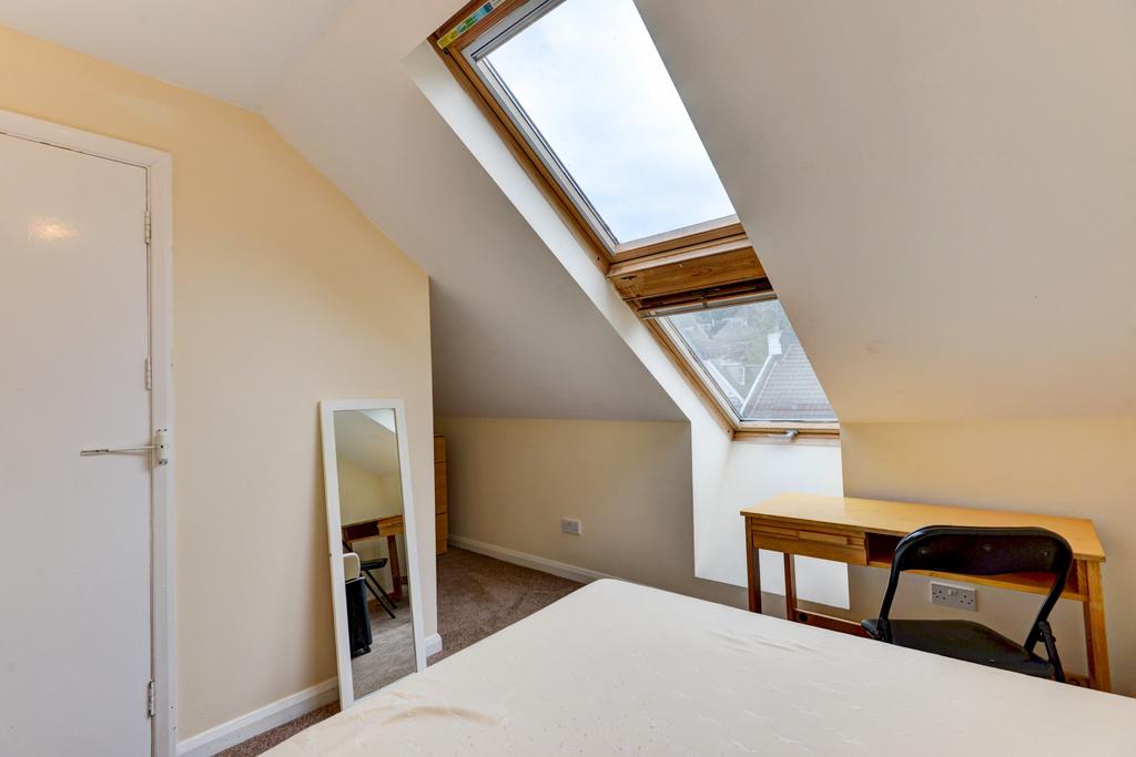 A bright and welcoming bedroom with a large sky...