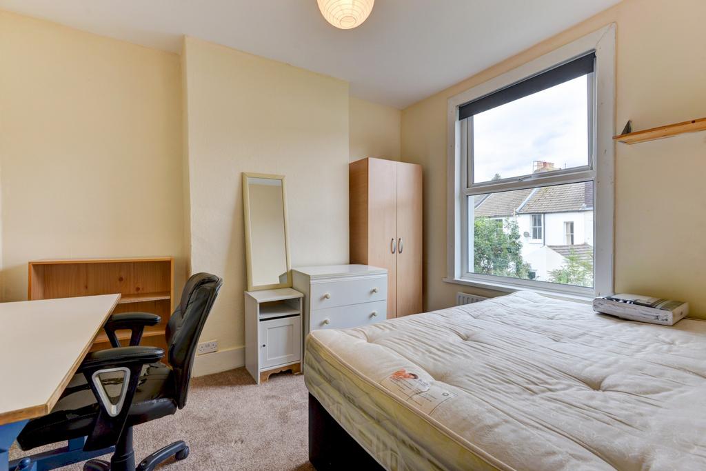 A well-lit bedroom featuring a spacious double ...